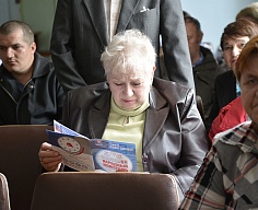 Жительница изучает брошюру по управлению многоквартирным домом